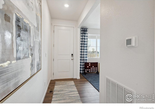 entryway with baseboards, visible vents, and wood finished floors