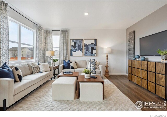 living area featuring recessed lighting, baseboards, and wood finished floors