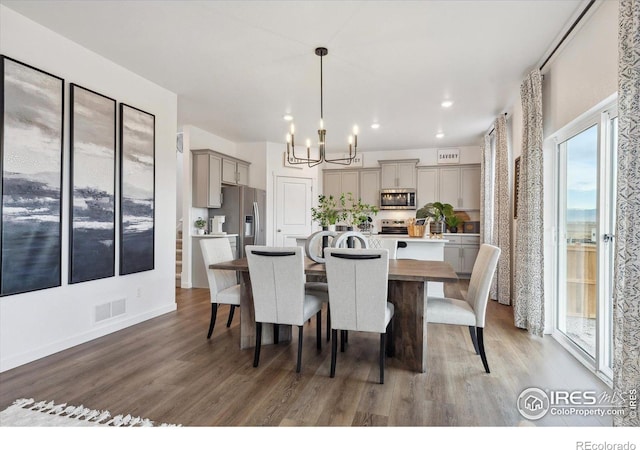 dining space featuring recessed lighting, visible vents, an inviting chandelier, and wood finished floors