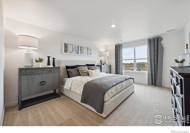 bedroom featuring light colored carpet, visible vents, and baseboards