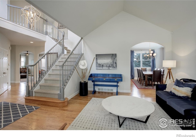 living room with arched walkways, wood finished floors, and a wealth of natural light