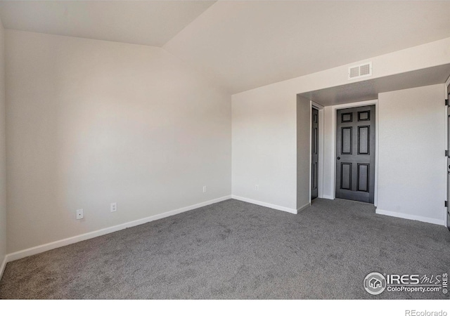 empty room with dark carpet, visible vents, and baseboards