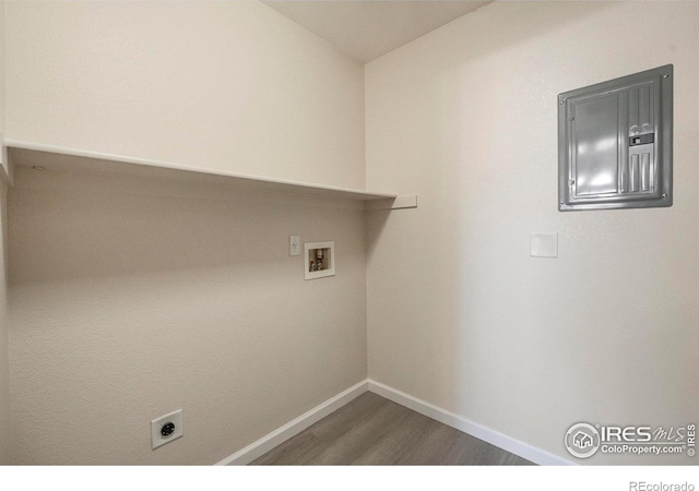 laundry area featuring hookup for a washing machine, wood finished floors, laundry area, electric panel, and baseboards