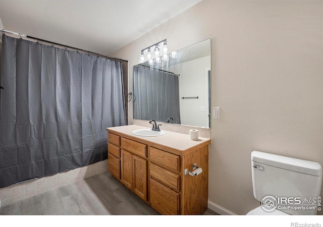 bathroom with vanity, a shower with shower curtain, wood finished floors, and toilet