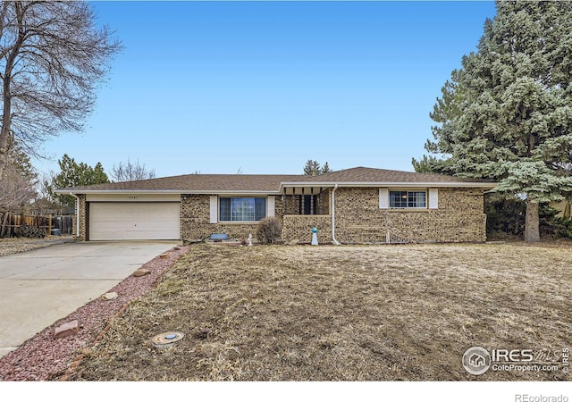 ranch-style home featuring a garage, driveway, and brick siding