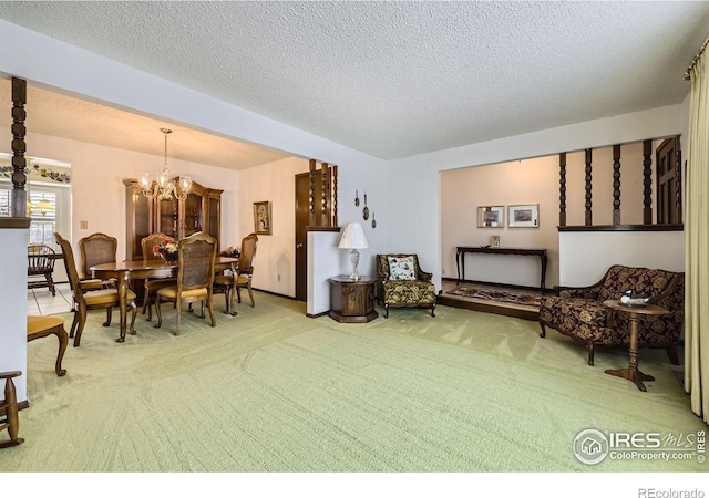 living area featuring carpet, a textured ceiling, and an inviting chandelier