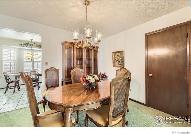 dining room with light colored carpet, a notable chandelier, a textured ceiling, and light tile patterned floors