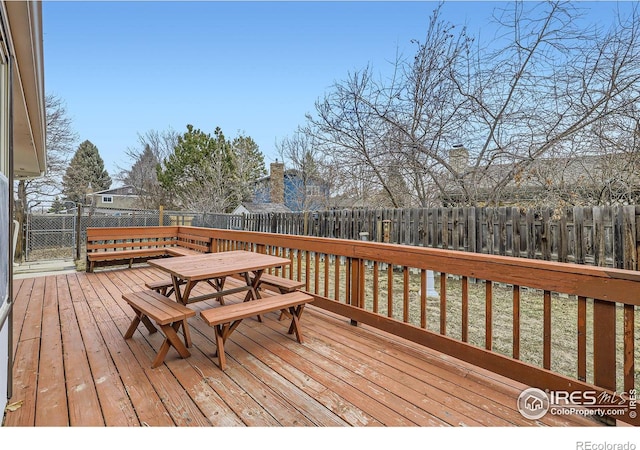 deck with outdoor dining area and a fenced backyard