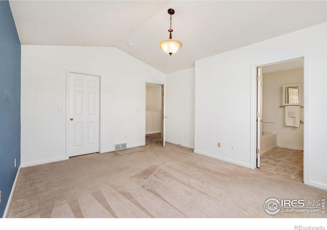 unfurnished bedroom featuring carpet, visible vents, baseboards, and vaulted ceiling