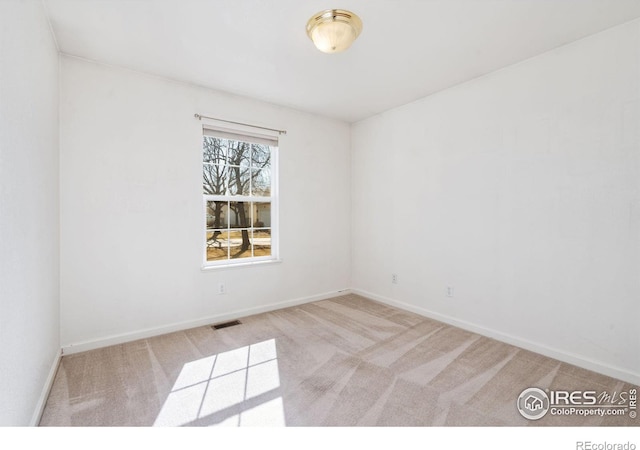 unfurnished room with carpet flooring, visible vents, and baseboards