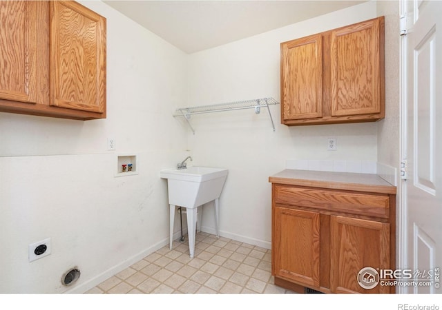 clothes washing area featuring washer hookup, light floors, cabinet space, electric dryer hookup, and baseboards