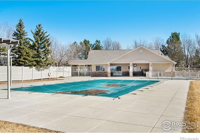 pool with a patio area and fence