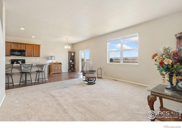 living area featuring recessed lighting, dark carpet, baseboards, and an inviting chandelier