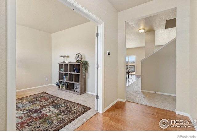 hall with wood finished floors and baseboards