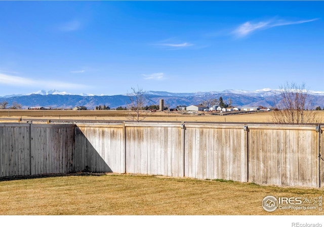 view of yard featuring a mountain view and fence