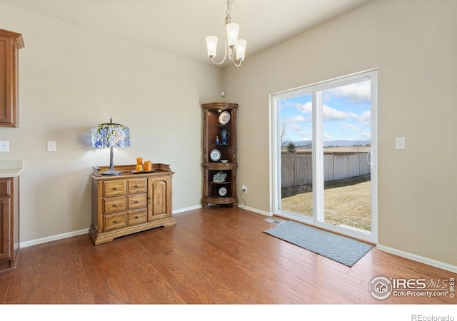 dining room featuring a chandelier, baseboards, visible vents, and wood finished floors