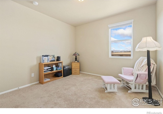 sitting room featuring baseboards and carpet