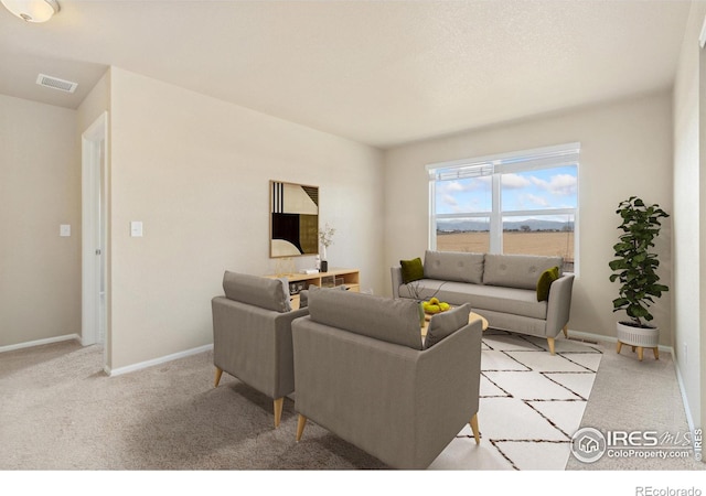 living room with light carpet, visible vents, and baseboards