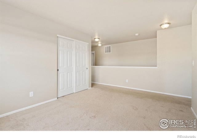 unfurnished room with visible vents, baseboards, and carpet flooring