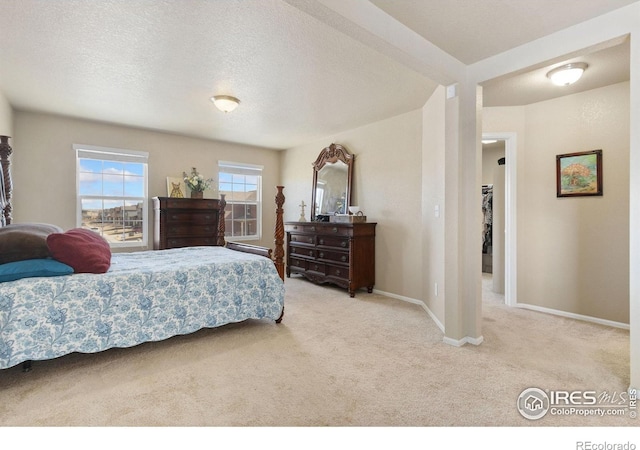 carpeted bedroom with a textured ceiling and baseboards