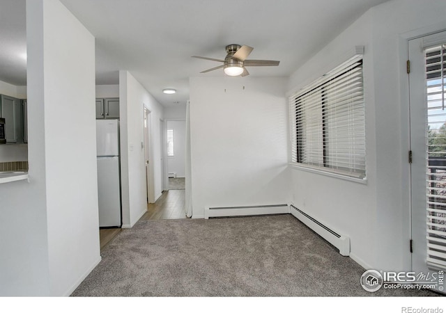 unfurnished room with a ceiling fan, carpet, baseboards, and a baseboard radiator