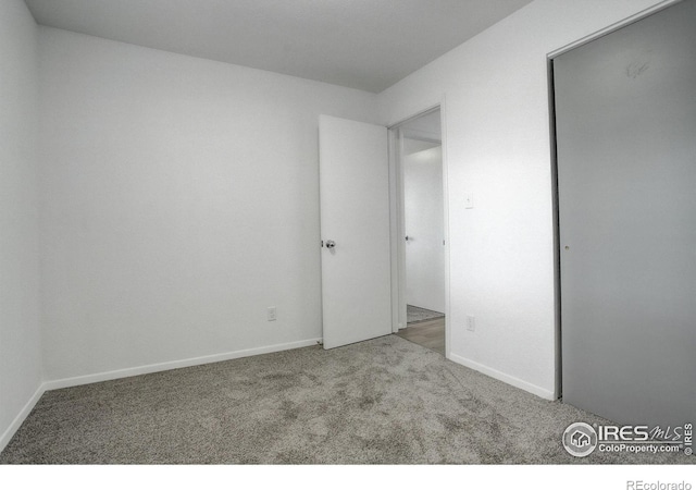 unfurnished bedroom featuring carpet floors and baseboards