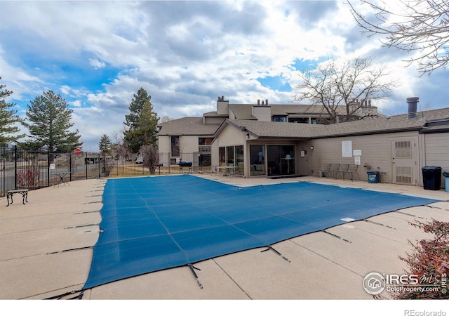 pool with a patio and fence