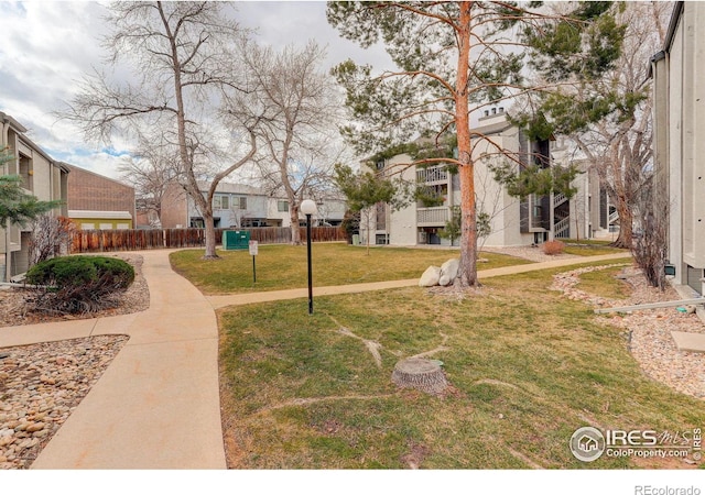 surrounding community featuring a lawn, fence, and a residential view