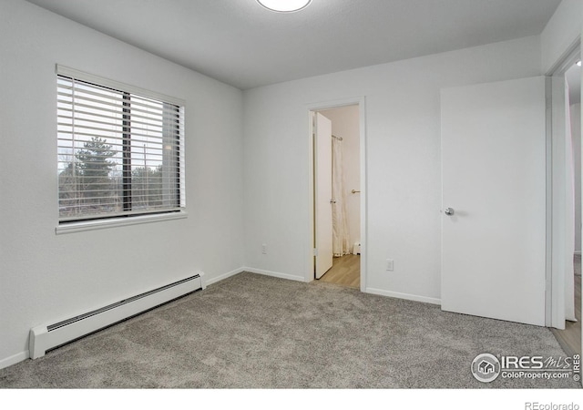 unfurnished bedroom featuring carpet, baseboards, and baseboard heating