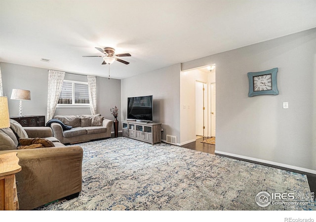 living area featuring a ceiling fan, visible vents, and baseboards