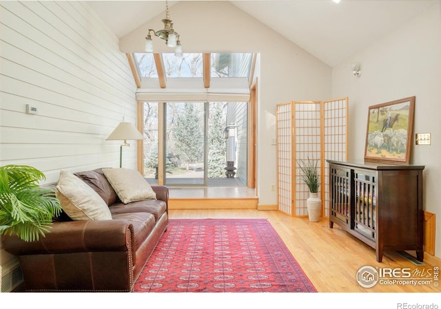 living area featuring high vaulted ceiling and wood finished floors