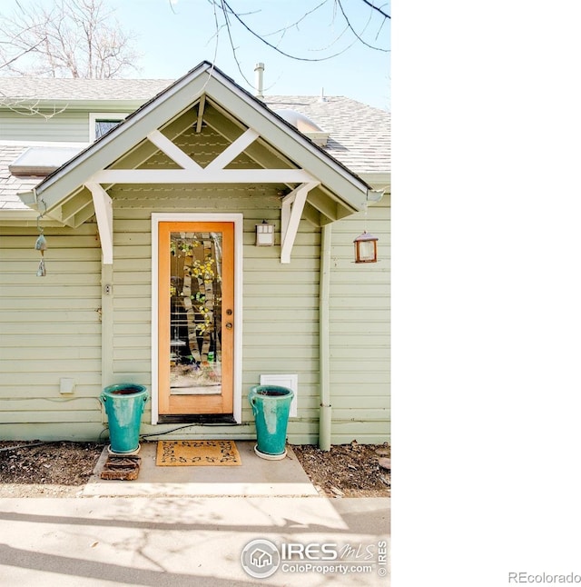 entrance to property with a shingled roof