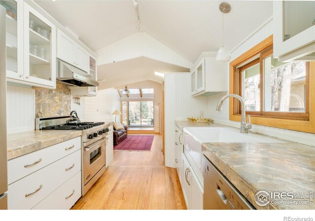 kitchen featuring under cabinet range hood, stainless steel appliances, vaulted ceiling, light countertops, and light wood finished floors