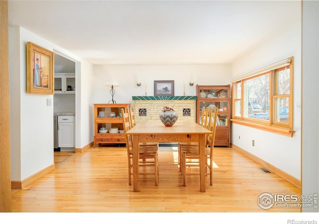 dining room with visible vents, light wood-style flooring, and baseboards