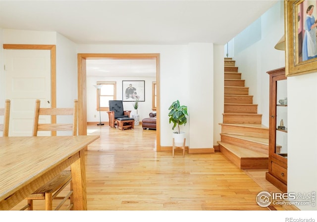 interior space with stairs, baseboards, and light wood-style floors