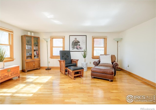 living area with baseboards and light wood finished floors