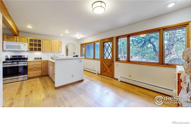 kitchen featuring stainless steel gas range, a baseboard heating unit, a peninsula, and white microwave