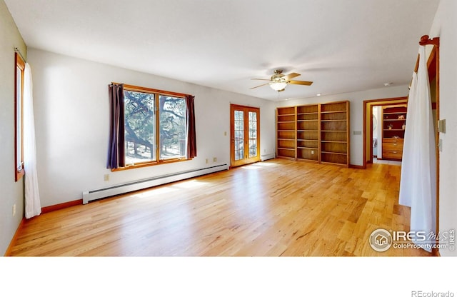 spare room with a baseboard radiator, a ceiling fan, baseboards, light wood-style floors, and french doors