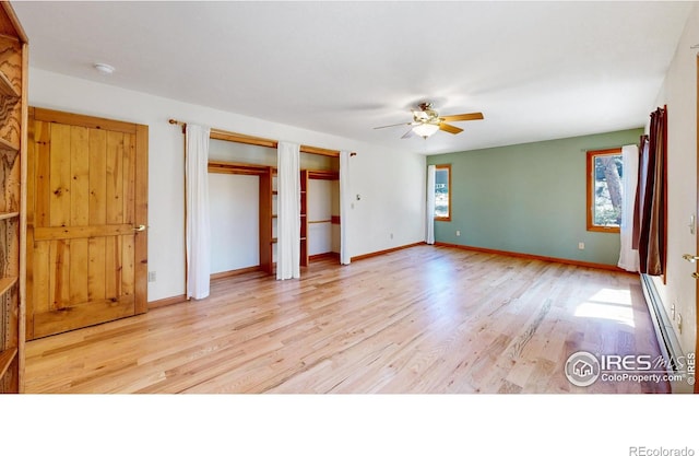 unfurnished bedroom featuring baseboards, ceiling fan, wood finished floors, and multiple closets