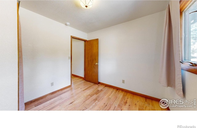 empty room featuring baseboards and wood finished floors