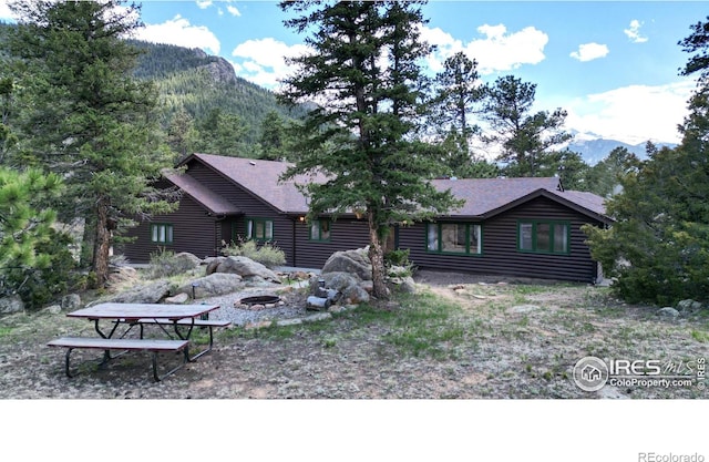 cabin with an outdoor fire pit and a mountain view