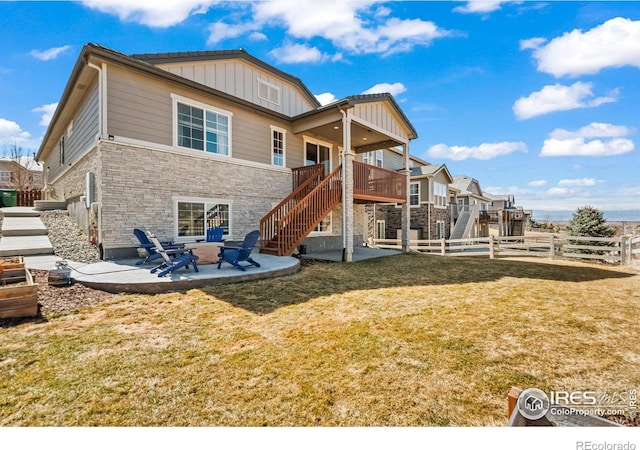 rear view of property with a patio, fence, a yard, stairway, and board and batten siding