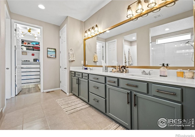 full bathroom with double vanity, visible vents, a spacious closet, a sink, and tile patterned flooring