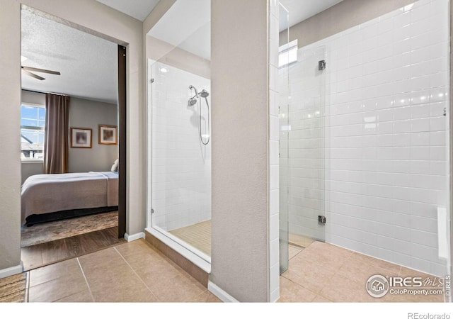 full bathroom featuring a textured ceiling, connected bathroom, baseboards, tile patterned floors, and walk in shower