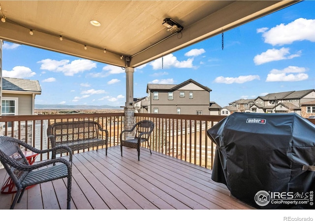 wooden deck featuring grilling area and a residential view