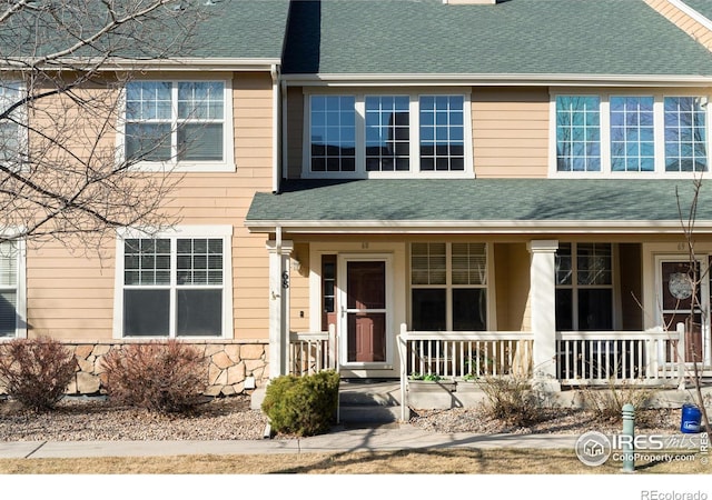 view of front of home featuring a porch, stone siding, and a shingled roof