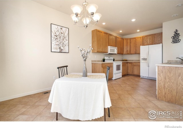 kitchen with a notable chandelier, recessed lighting, light countertops, a sink, and white appliances