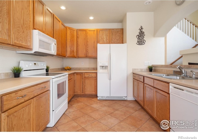 kitchen featuring recessed lighting, white appliances, light countertops, and a sink