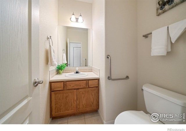 bathroom featuring tile patterned flooring, vanity, and toilet