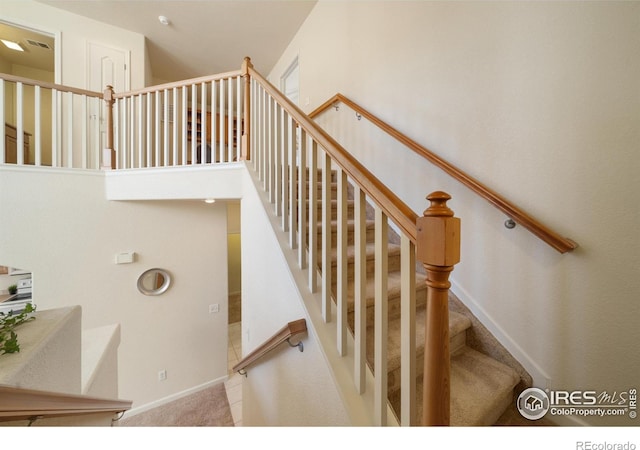 stairs with carpet floors and baseboards